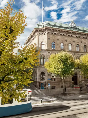 En spårvagn åker förbi ett par äldre byggnader i Göteborg