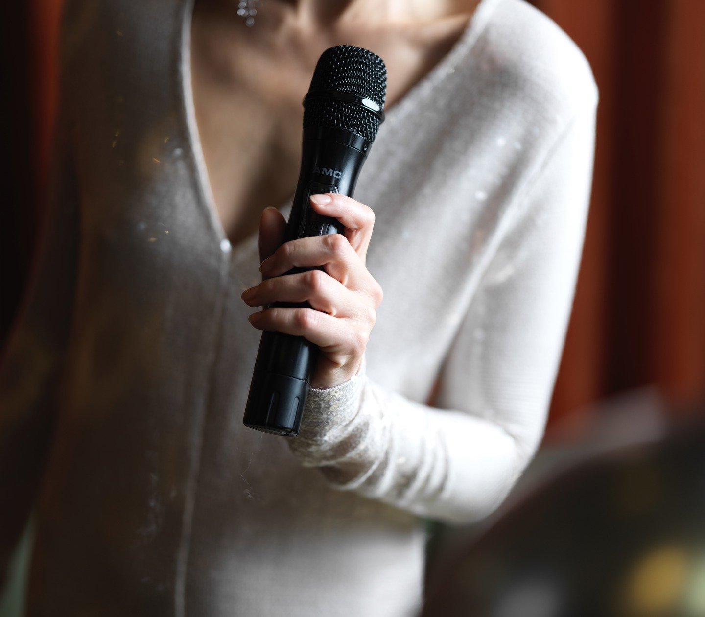 A woman in a sparkling dress holds a microphone