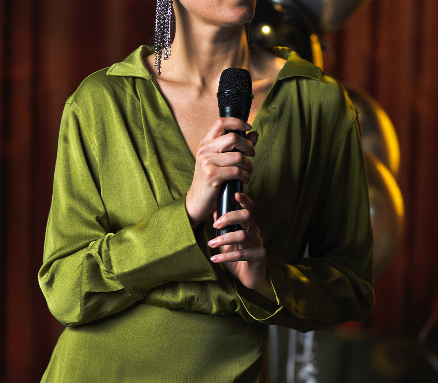 En kvinna i grön klänning håller i en mikrofon