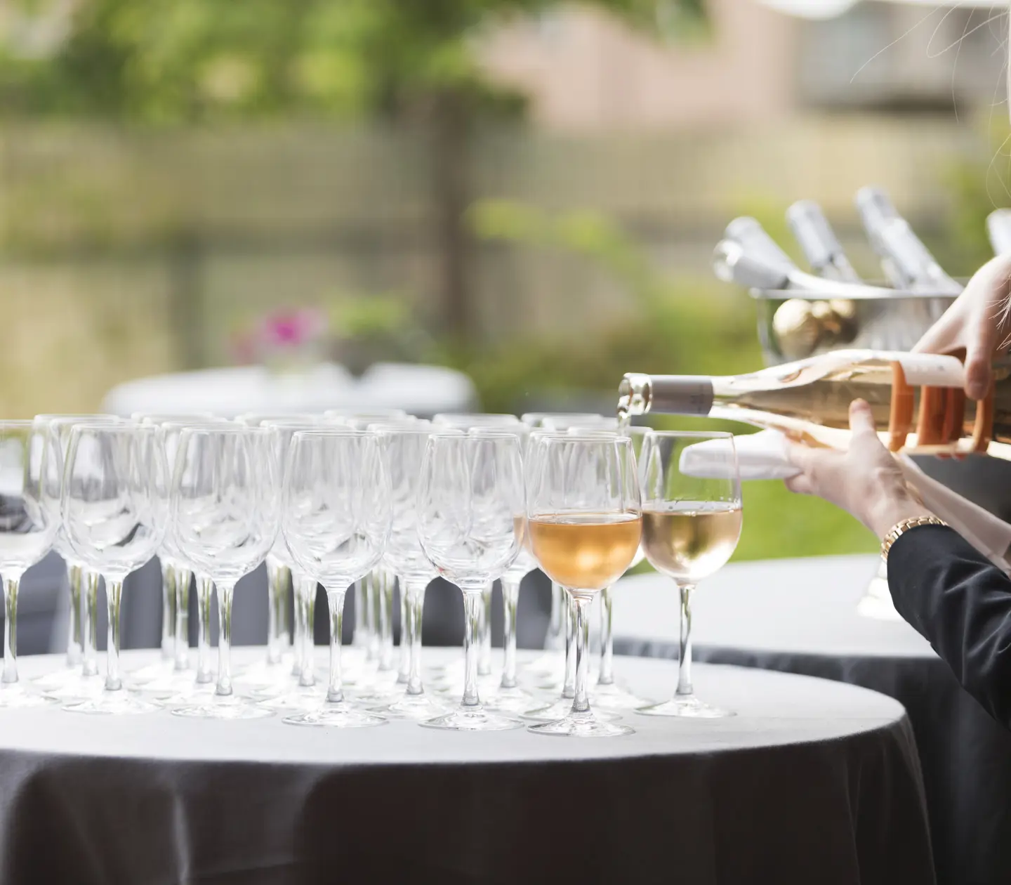 Waiter fills champagne glasses with champagne