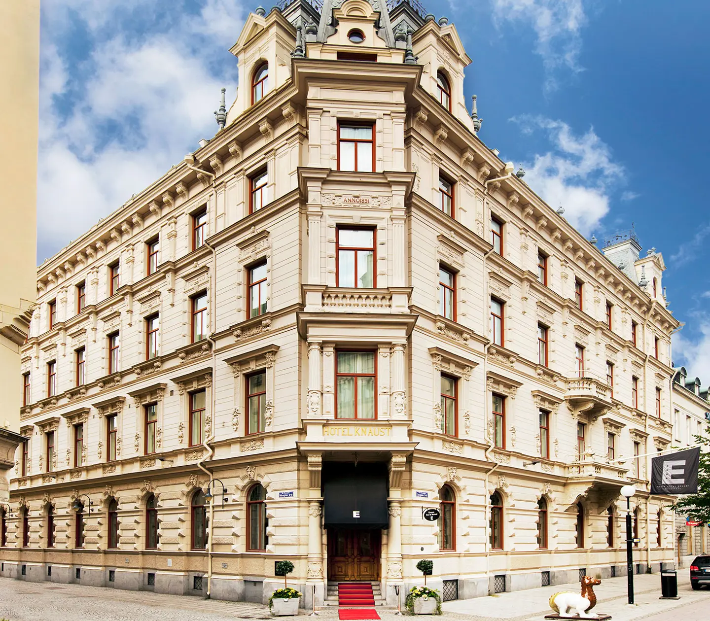 A large white corner building in a city