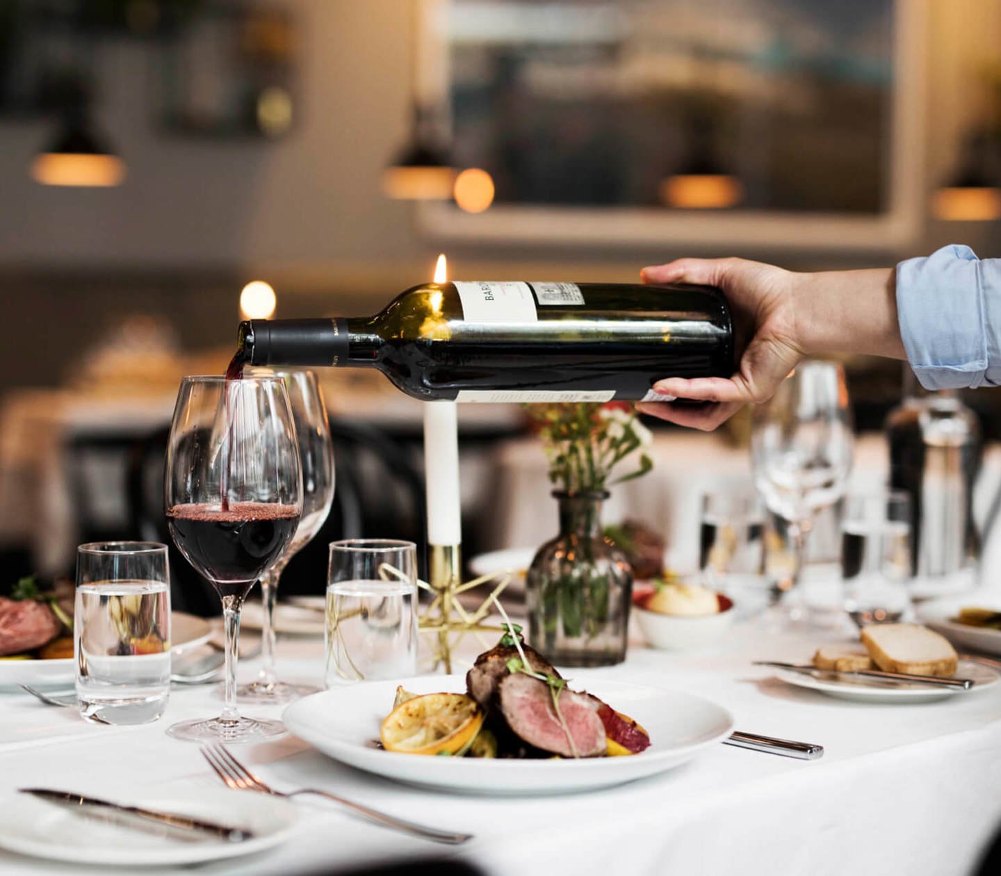 Servitör häller upp vin i glas på en restaurang