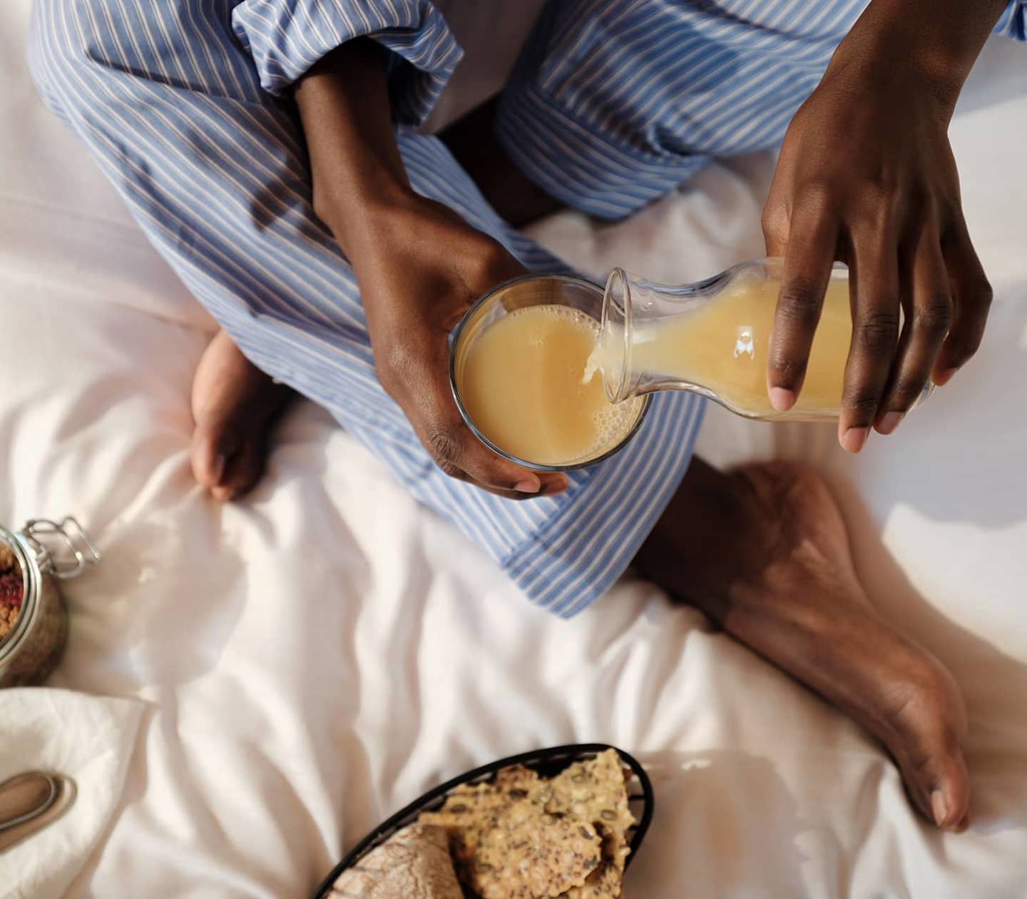 Person i en säng som äter frukost