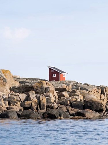 Litet hus på klippor i Sveriges skärgård