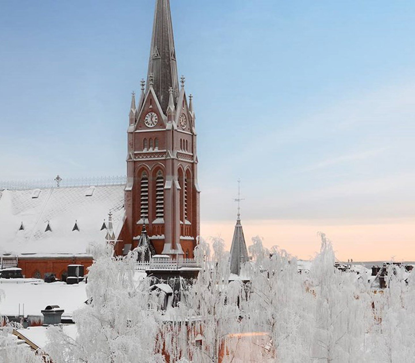 Snöigt stadslandskap med kyrka och blå himmel