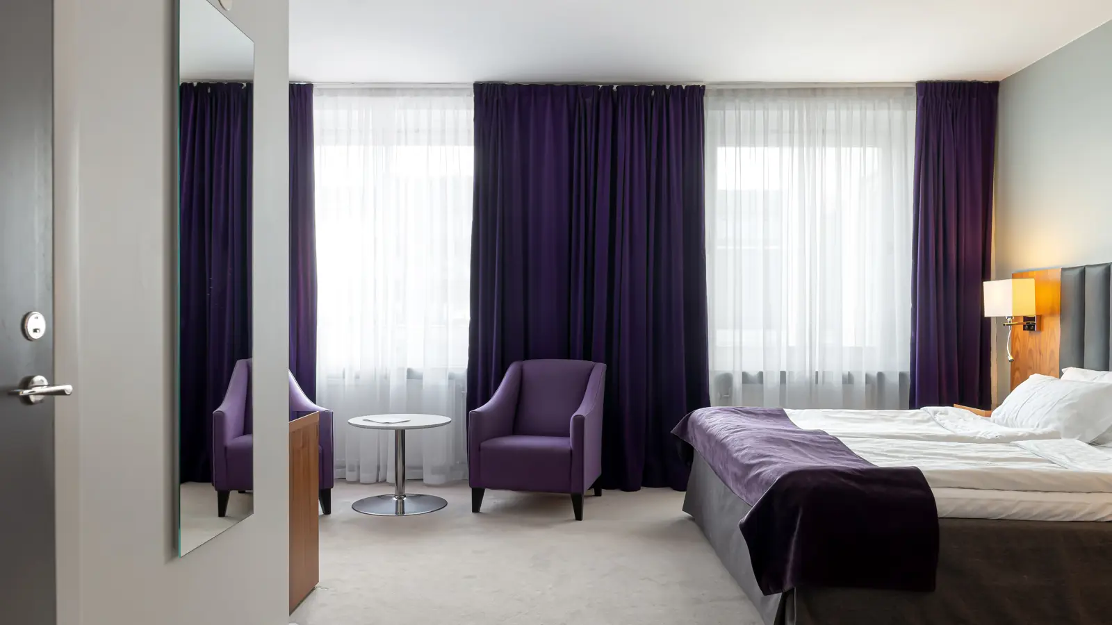 Hotel Room with a made bed and cozy lighting
