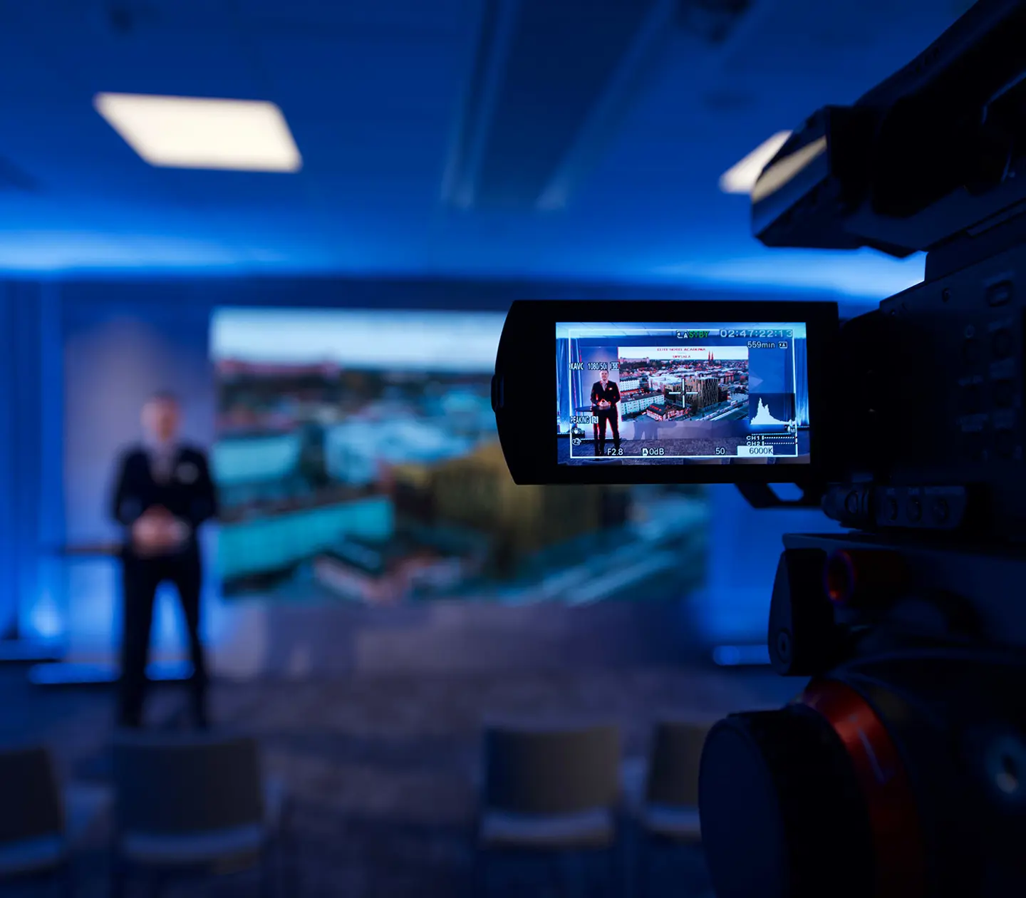 A man holding a presentation and a camera recording him