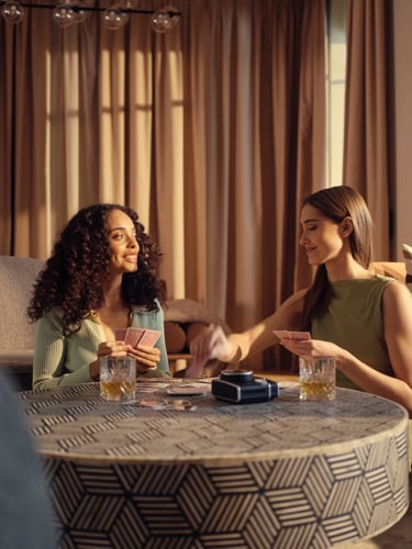 Two women playing cards in hotel room