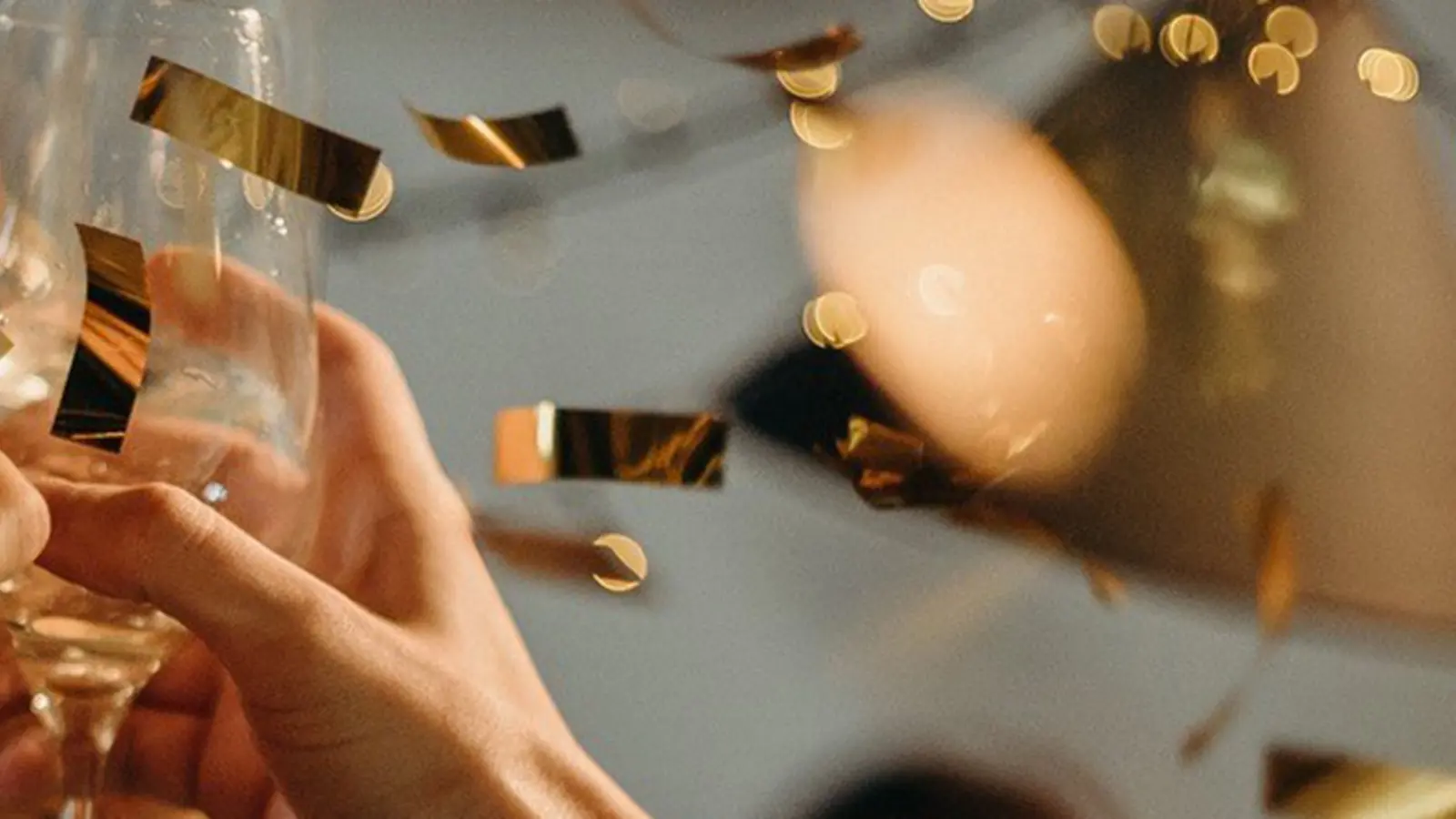 Folk skålar medans det faller konfetti på en nyårsfest