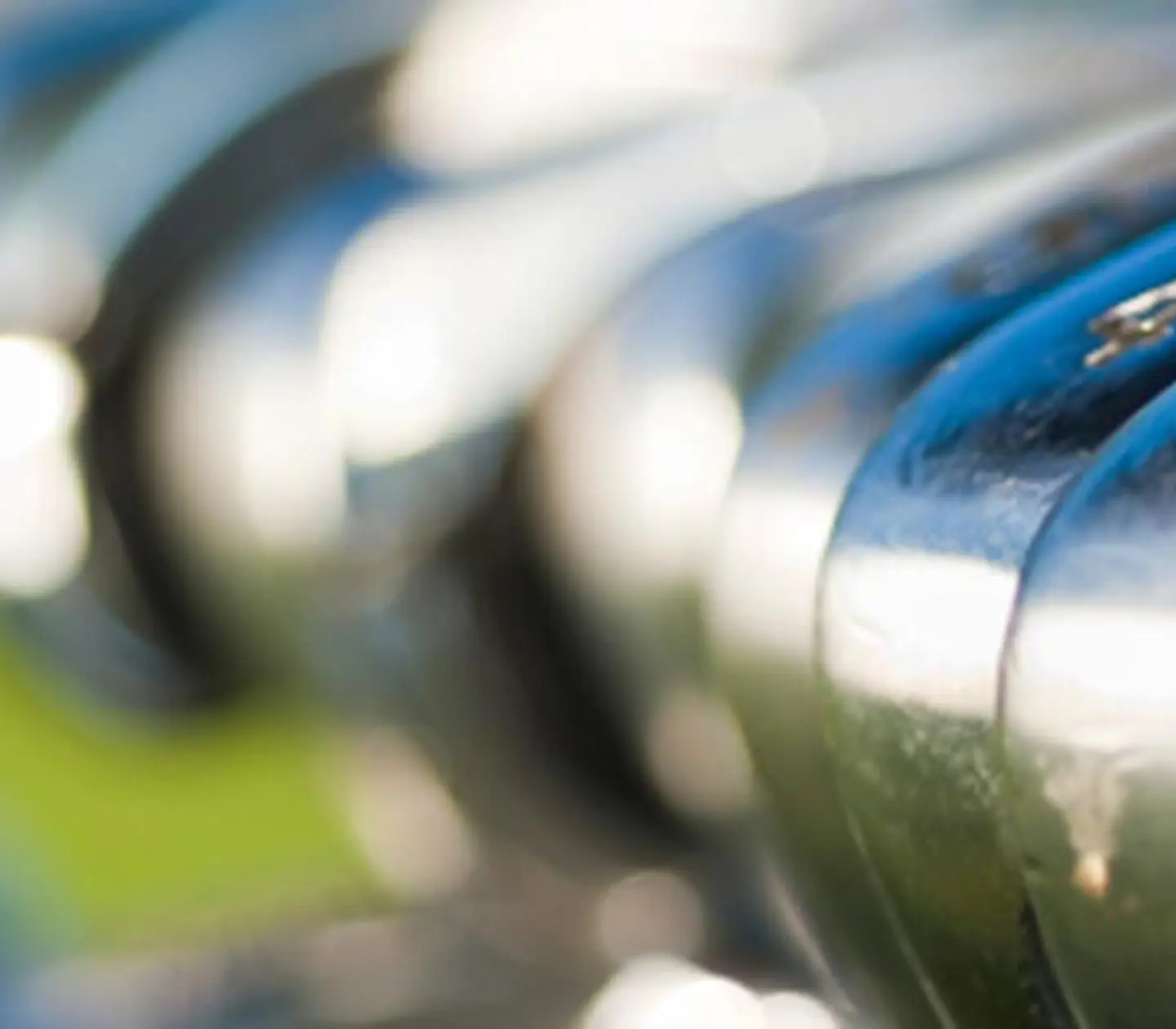 Golfklubbor med en golfbana i bakgrunden