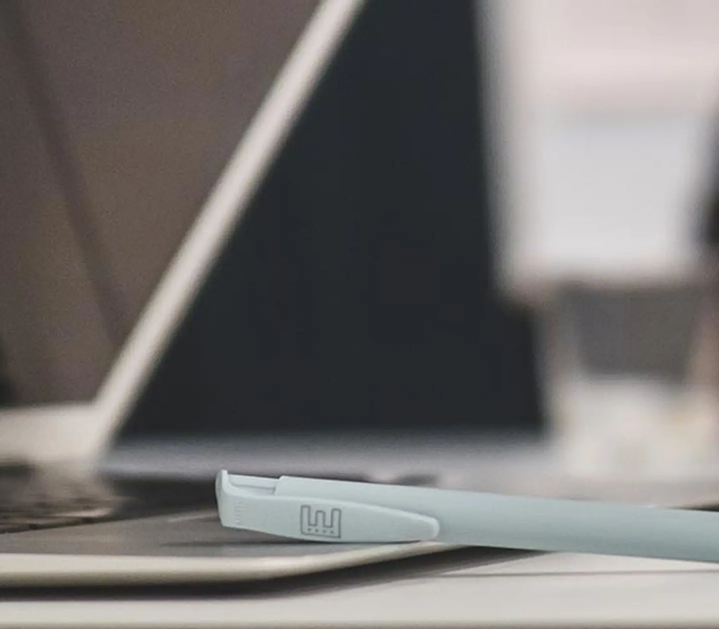 A laptop and pen lying on a conference table