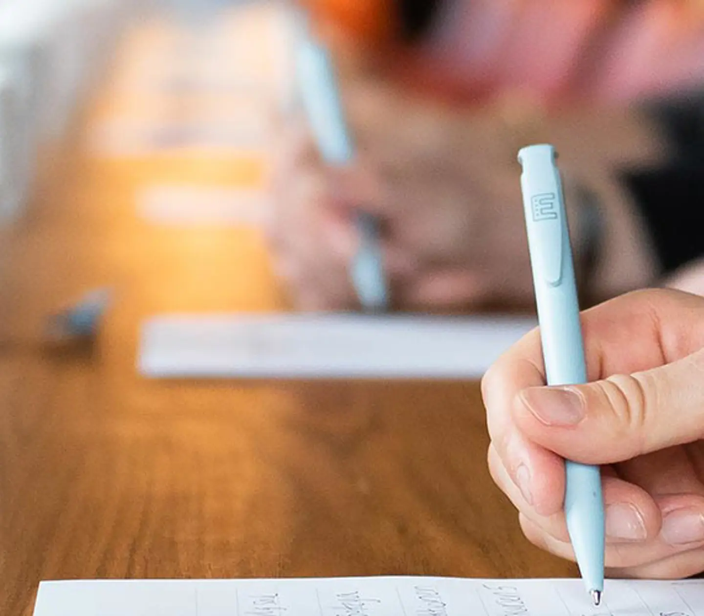 Personer antecknar på papper med kaffekoppar framför sig