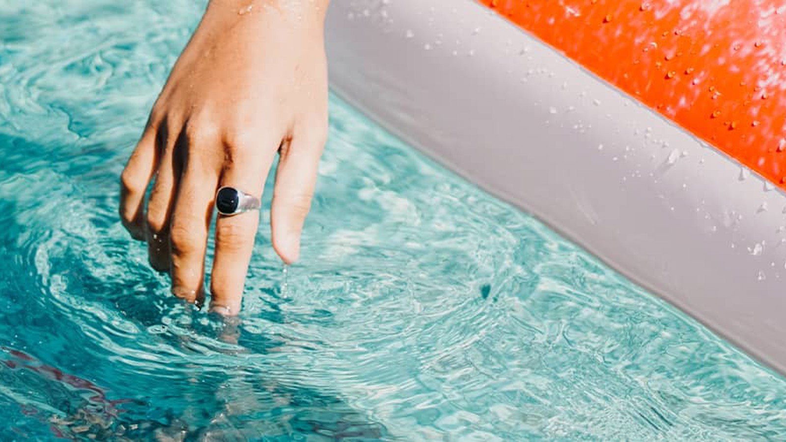 Hand som doppar fingrarna i en pool