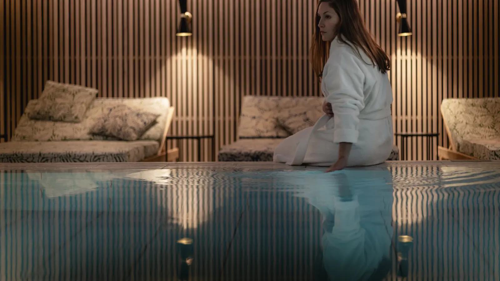 Kvinna sittandes på kanten på en pool