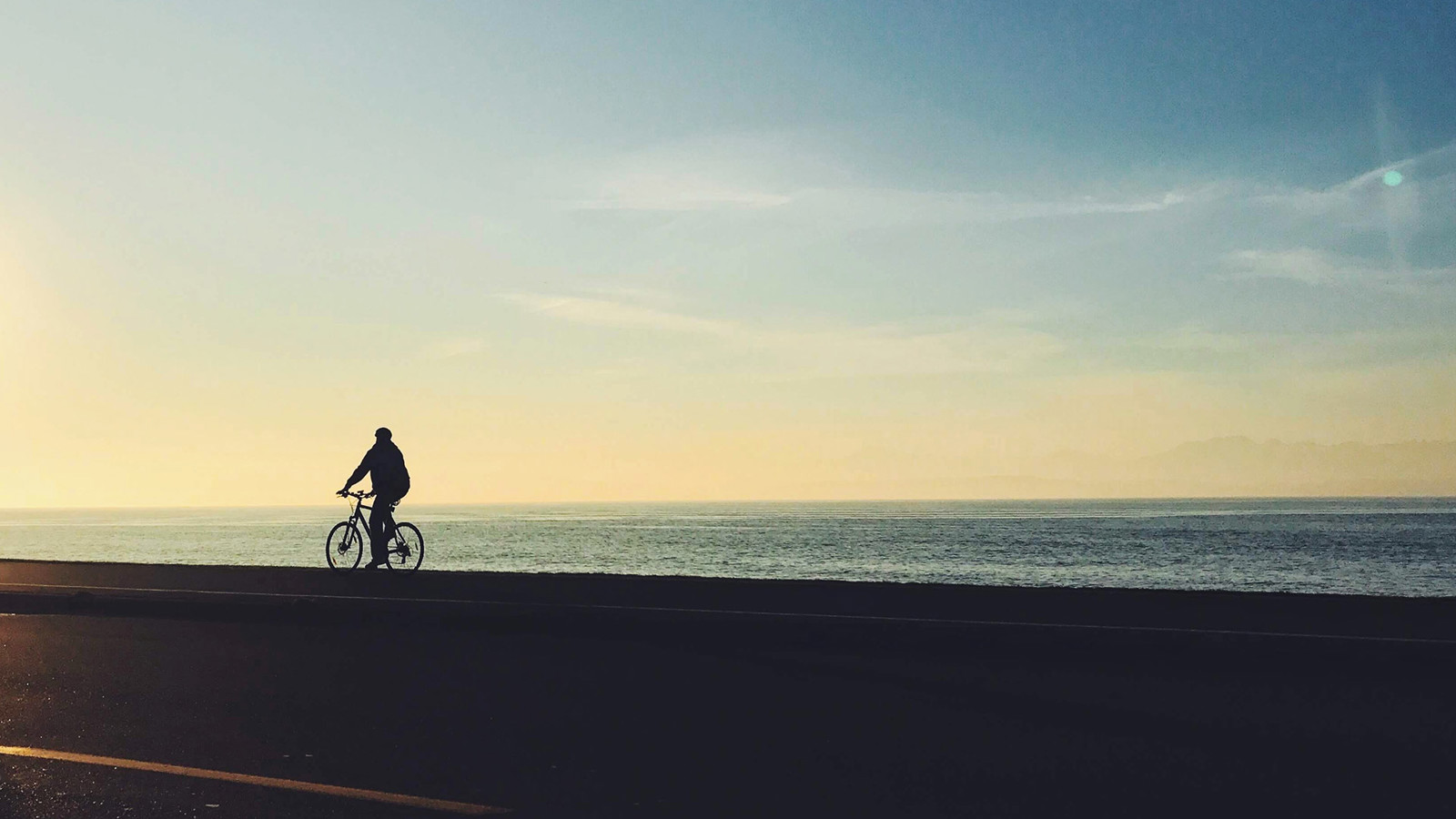 Person cyklar längs med kusten