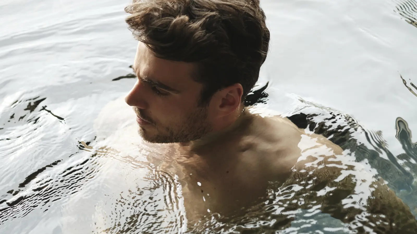 En man som badar i en pool