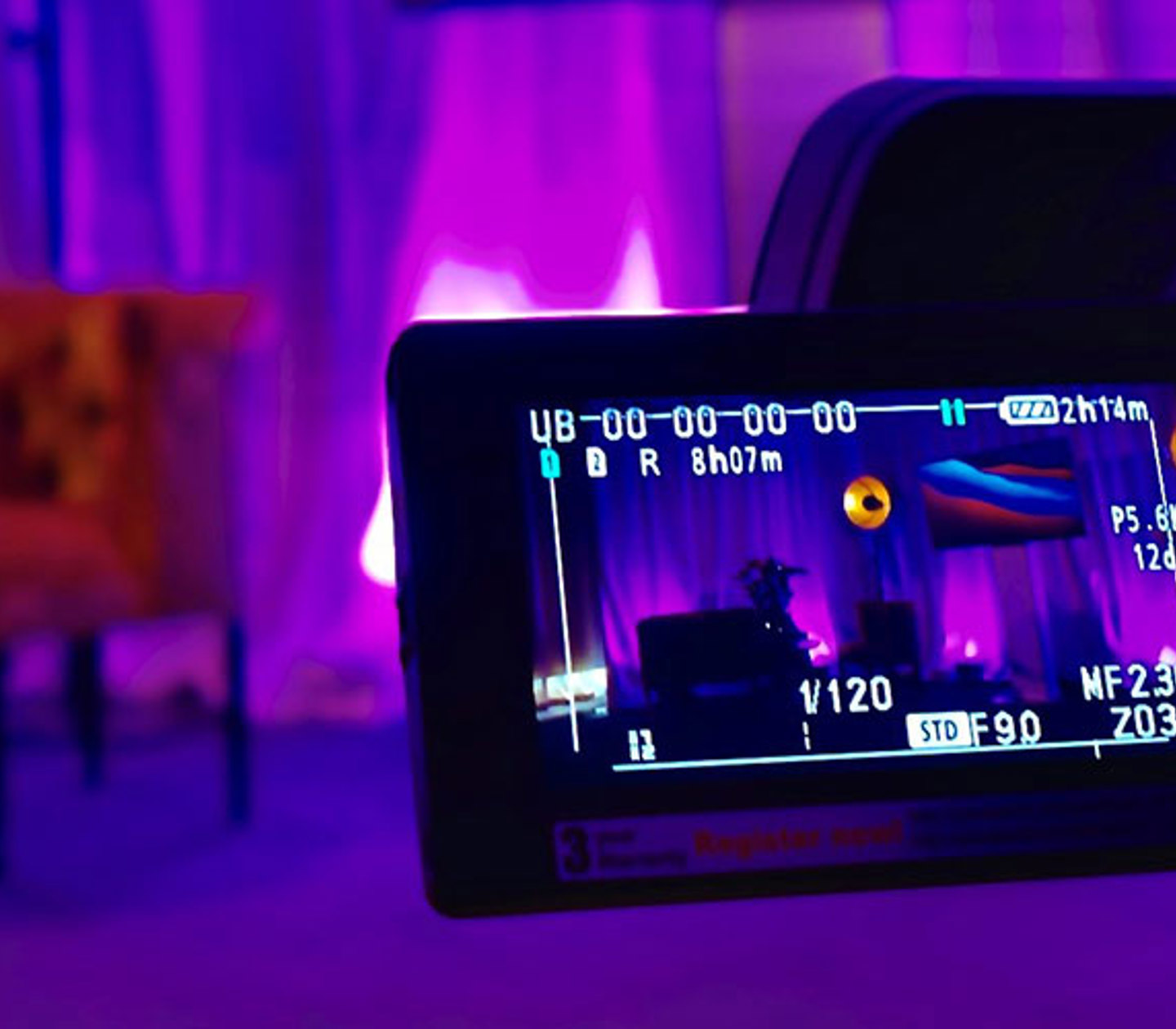 Studiomiljö med lila belysning och filmkamera