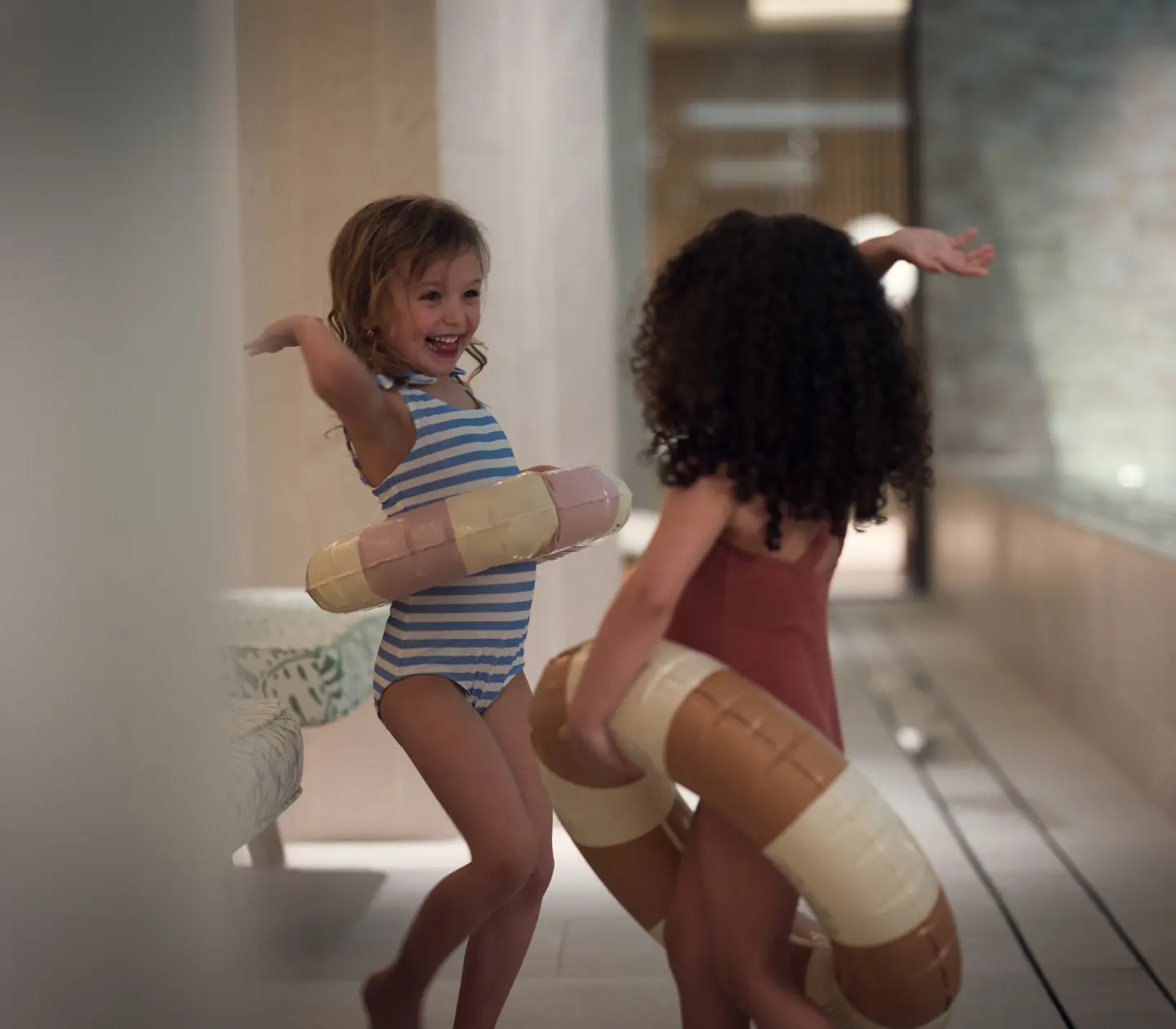 Children with swimming rings at the edge of a pool