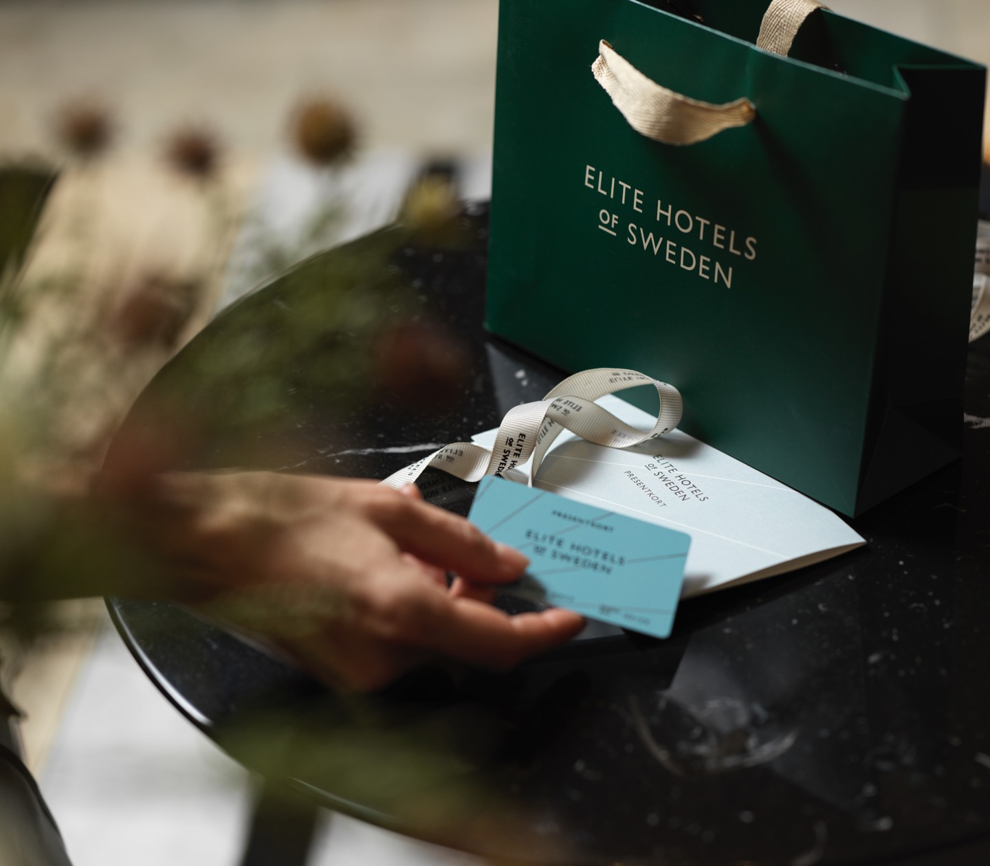 Person holding gift card from Elite hotels