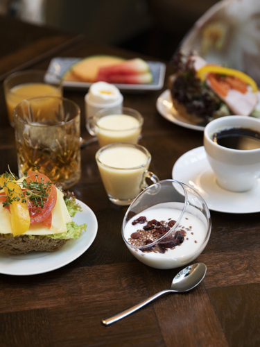 Frukost med smörgås och kaffe framdukad på bord 