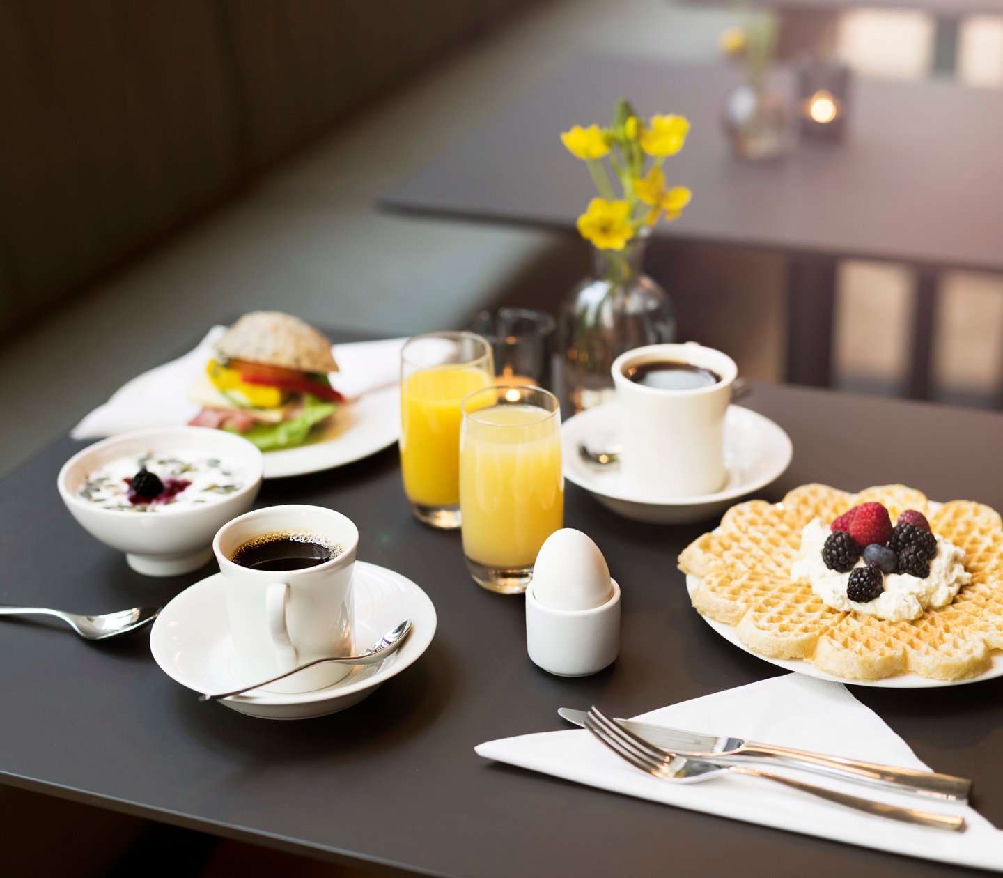 Breakfast laid out on the table with juice, coffee and waffles