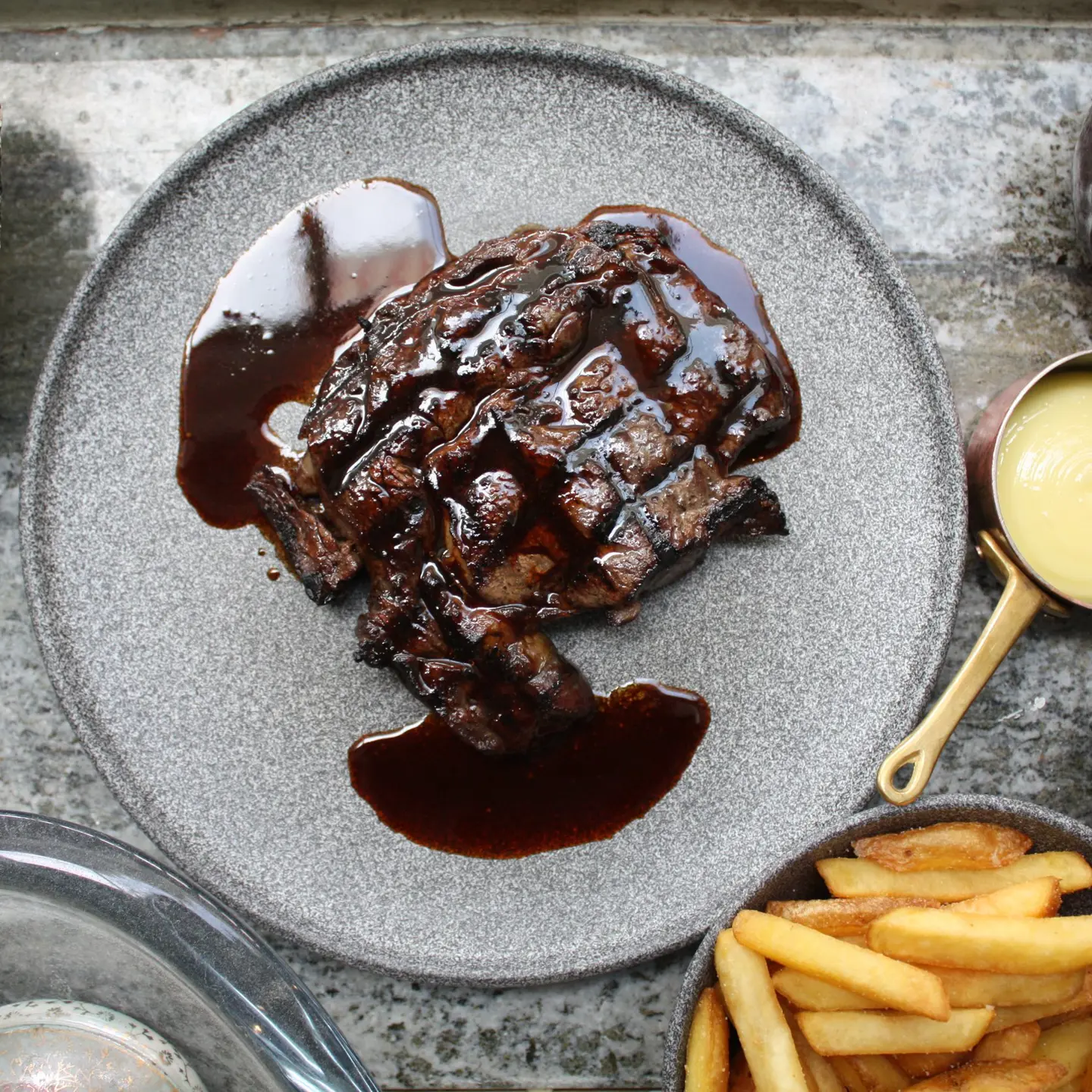 A steak served with fries and sauce