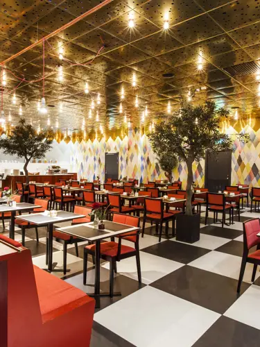Restaurang med röda stolar och rutigt golv i svart och vitt