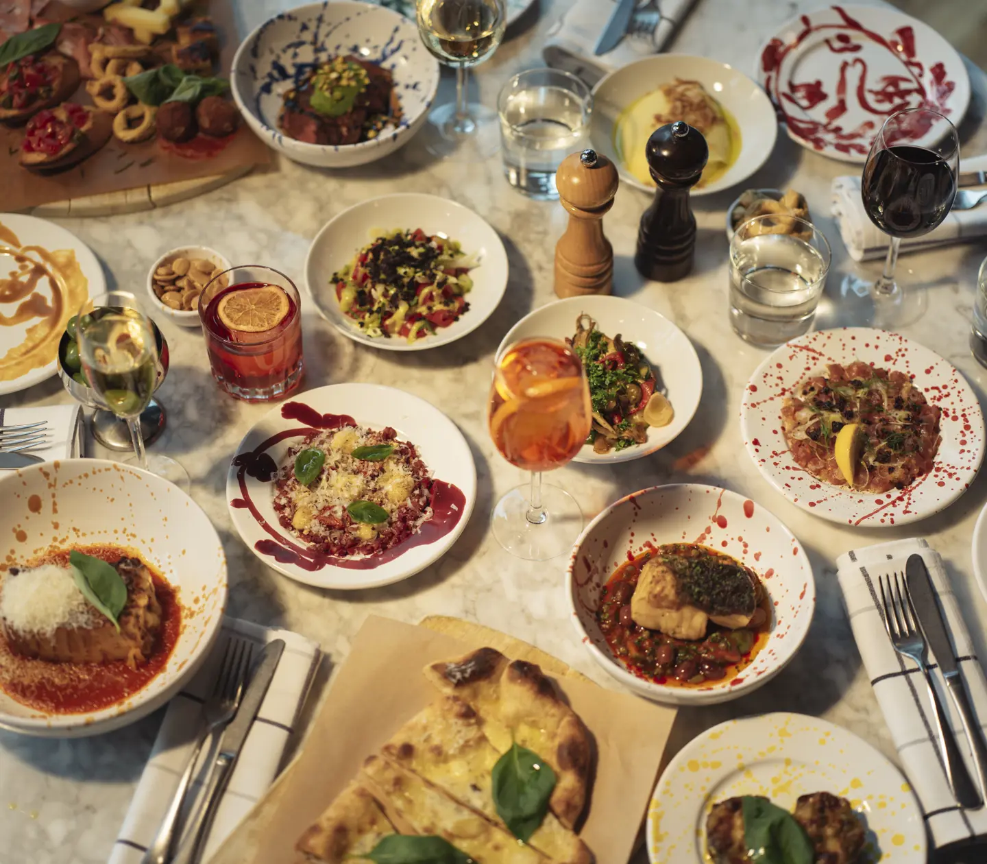 A pizza with ruccola and olives on the side